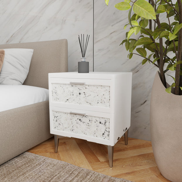 Slate nightstand styled next to an upholstered bed in a modern bedroom
